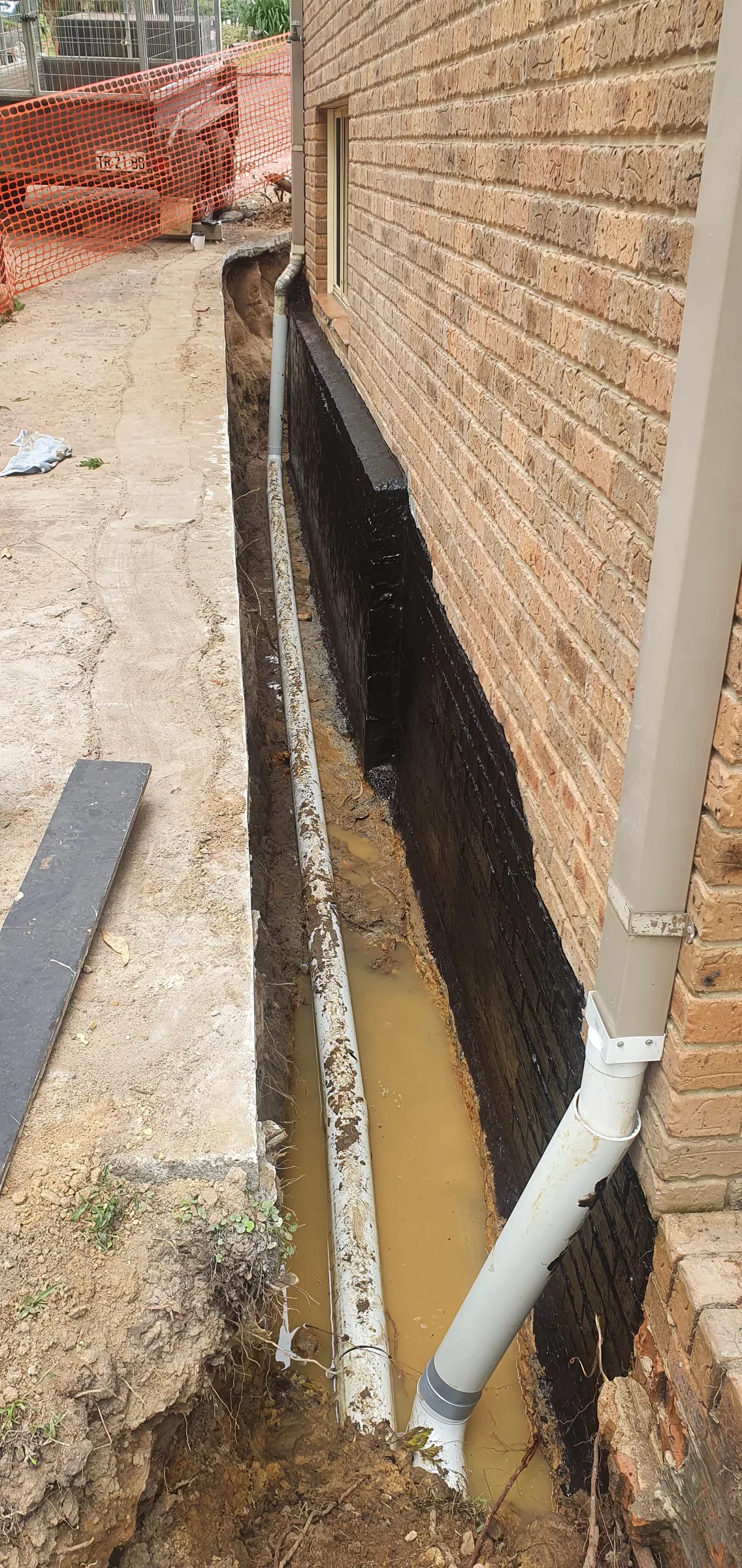 A new PVC stormwater pipe run installed under a subfloor
